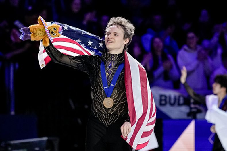 El estadounidense Ilia Malinin saluda a los espectadores con la medalla de oro tras ganar el programa libre masculino del Campeonato del Mundo de Patinaje en Praga, República Checa el sábado 28 de marzo del 2026. (AP Foto/Petr David Josek)