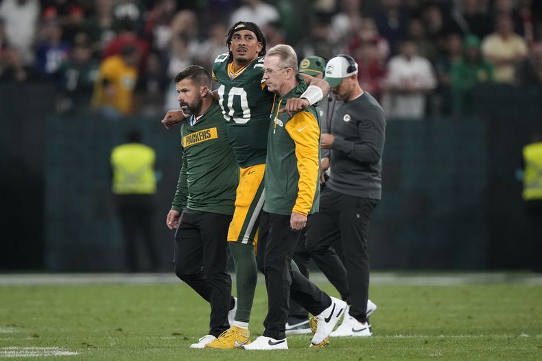 Jordan Love (10), quarterback de los Packers de Green Bay, es asistido para salir del campo de juego después de resultar lesionado en la segunda mitad del partido de la NFL en contra de los Eagles de Filadelfia, el viernes 6 de septiembre de 2024, en la Arena Neo Quimica, en Sao Paulo, Brasil. (AP Foto/Doug Benc)
