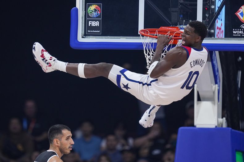 El escolta de Estados Unidos Anthony Edwards celebra una clavada sobre el pívot de Jordania Ahmad Dwairi (44) en la primera mitad del partido por el Grupo C del Mundial, el miércoles 30 de agosto de 2023, en Manila, Filipinas. (AP Foto/Michael Conroy)