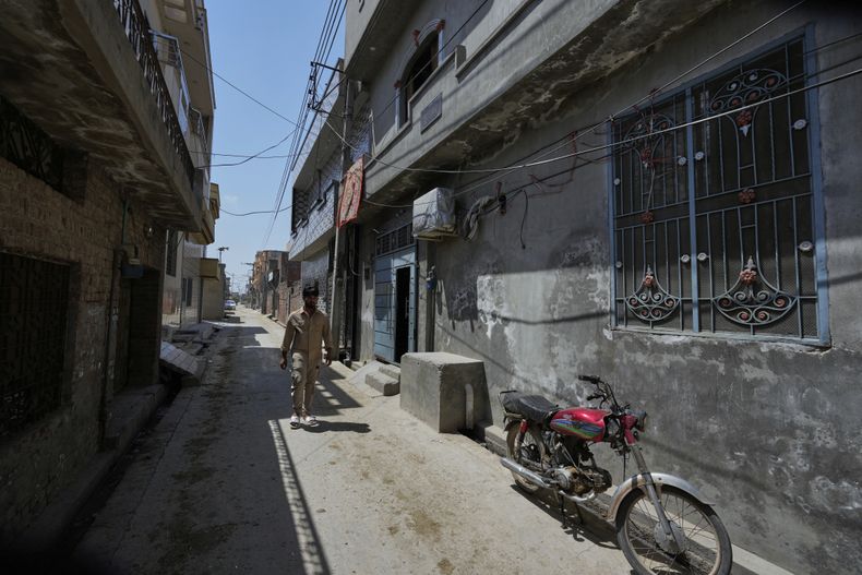 Amir Ali, que sobrevivió a un intento fallido de llegar a España por mar, camina por una calle cerca de su casa en Dera Bajwa, una localidad del distrito de Gujranwala, Pakistán, el 23 de abril de 2025. (AP Foto/Anjum Naveed)