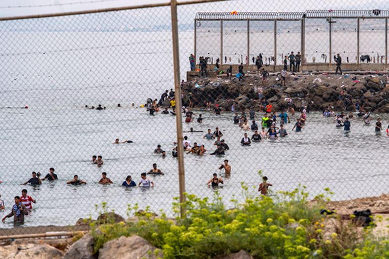 Varios migrantes tratan de cruzar desde Marruecos hacia el enclave español de Ceuta, el viernes 31 de julio de 2026. (AP Foto/Antonio Sempere)