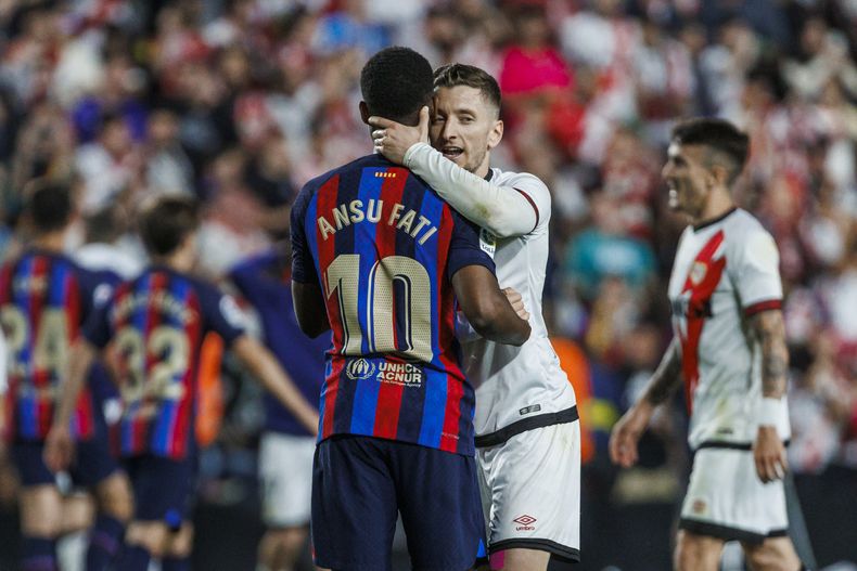 Ivan Balliu (derecha), de Rayo Vallecano, abraza a Ansu Fati, del Barcelona, al final de un partido de La Liga, el miércoles 26 de abril de 2023 (AP Foto/Pablo García)