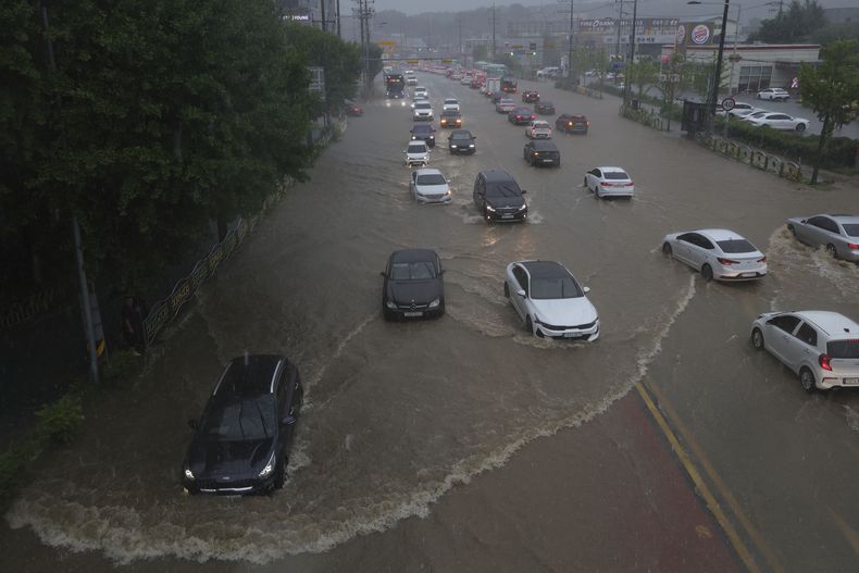 Vehículos circulan por una calle anegada por las fuertes lluvias en Uijeongbu, Corea del Sur, el 13 de agosto de 2025. (Lim Byung-shick/Yonhap vía AP)