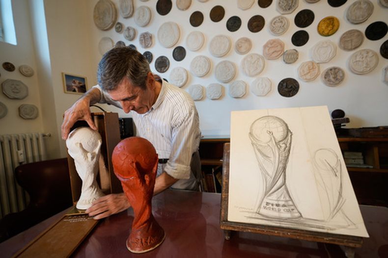 Giorgio Gazzaniga, hijo del escultor Silvio Gazzaniga, coloca la escultura original de yeso de la Copa del Mundo en un estuche de madera dentro de una bodega en Pioltello, Italia, el sábado 11 de julio de 2026 (AP Foto/Luca Bruno)