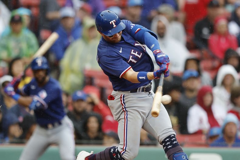 Robbie Grossman de los Rangers de Texas batea un doble remolcador en la cuarta entrada del juego ante los Medias Rojas de Boston el martes 4 de julio del 2023. (AP Foto/Michael Dwyer)