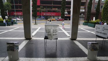 Una mujer pasa por detrás de varias urnas de votación en las primeras elecciones judiciales de México, en Ciudad de México, el domingo 1 de junio de 2025. (AP Foto/Marco Ugarte)