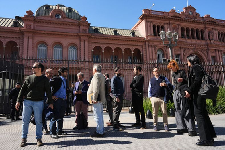 Periodistas permanecen afuera de la Casa Rosada, sede del gobierno, después de que el presidente Javier Milei les bloqueara el acceso, el jueves 23 de abril de 2026, en Buenos Aires, Argentina. (AP Foto/Rodrigo Abd)