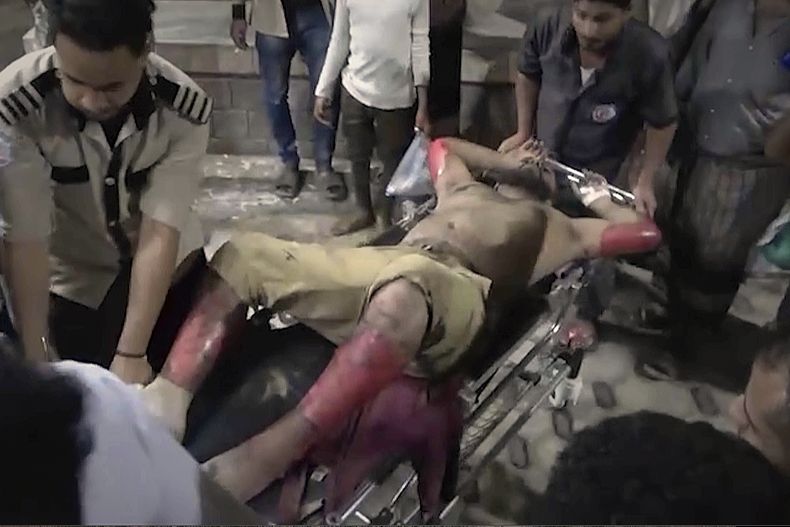 Este fotograma tomado de un video del canal de TV Al Masirah TV muestra a socorristas que llevan a un hombre que resultó herido por los bombardeos de EEUU contra el puerto yemení de Ras Isa el viernes 18 de abril de 2025.( Al Masirah TV vía AP)