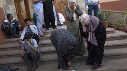 Palestinos llorando a familiares muertos en bombardeos israelíes en la Franja de Gaza, en una morgue en Khan Younis, el martes 17 de octubre de 2023. (AP Foto/Fatima Shbair)