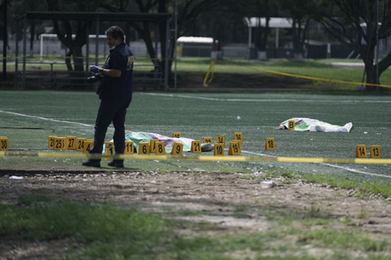 Un investigador del Ministerio Público recaba evidencia cerca del cuerpo de un exfiscal antipandillas, en un campo de fútbol, el sábado 17 de octubre de 2026, en Ciudad de Guatemala. (AP Foto/Emmanuel Andres)