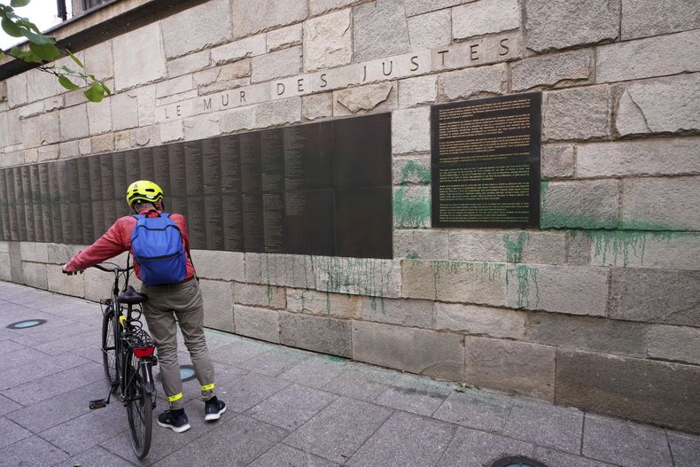 Un ciclista mira el Monumento a la Shoah en París, desfigurado con pintura verde después de que varios sitios judíos en la capital fueran pintarrajeados con ese color, el sábado, 31 de mayo de 2025 en París. (AP Foto/Aurelien Morissard)