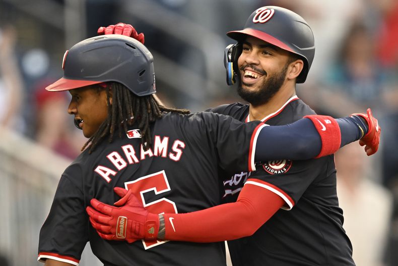 CJ Abrams, de los Nacionales de Washington, felicita a Luis García Jr., quien conectó un jonrón de tres carreras ante los Marineros de Seattle, el viernes 24 de mayo de 2024 (AP Foto/John McDonnell)