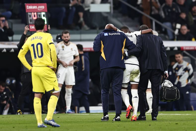 David Alaba, del Real Madrid, es asistido por el cuerpo médico del equipo para abandonar el campo durante el partido de la Liga de España entre Real Madrid y Villarreal en el estadio Santiago Bernebéu, en Madrid, España, el domingo 17 de diciembre de 2023. (AP Foto/Pablo Garcia)