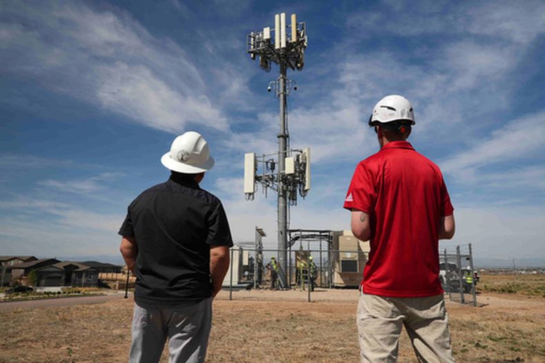 Trabajadores observan una torre que tiene cámaras para detectar incendios forestales, en Aurora, Colorado, el 20 de abril del 2026. (AP foto/Brittany Peterson)