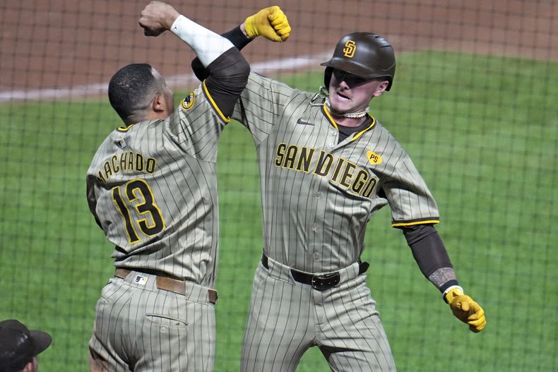Jackson Merrill de los Padres de San Diego celebra con Manny Machado su jonrón en la novena ante el relevista de los Piratas de Pittsburgh David Bednar el miércoles 7 de agosto del 2024. (AP Foto/Gene J. Puskar)