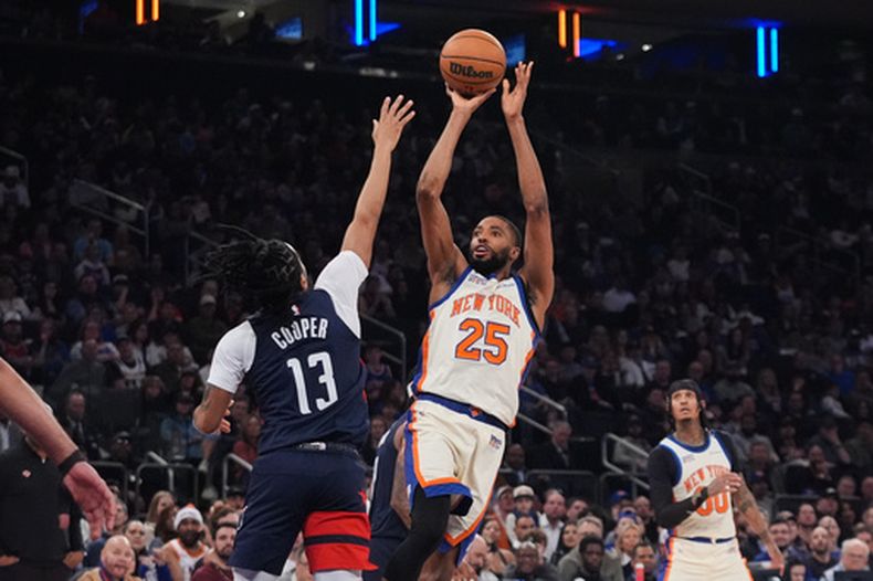 Mikal Bridges (25), de los Knicks de Nueva York, dispara sobre Sharife Cooper (13), de los Wizards de Washington, durante la primera mitad del juego de baloncesto de la NBA, el domingo 22 de marzo de 2026, en Nueva York. (AP Foto/Frank Franklin II)