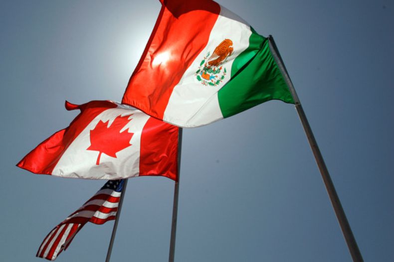 ARCHIVO - Banderas nacionales de Estados Unidos, Canadá y México ondean en la brisa en Nueva Orleans, donde se reunieron los líderes del Acuerdo Estados Unidos-México-Canadá el 21 de abril de 2008. (AP Foto/Judi Bottoni, Archivo)
