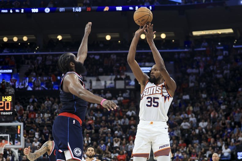 Kevin Durant, alero de los Suns de Phoenix, dispara frente a James Harden, de los Clippers de Los Ángeles, el miércoles 23 de octubre de 2024 (AP Foto/Ryan Sun)