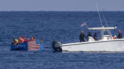 ARCHIVO - Personas en un barco improvisado con la bandera estadounidense pintada en el casco son capturadas por la Guardia Costera cubana, visto desde el Malecón en La Habana, Cuba, el 12 de diciembre de 2022. El gobierno cubano presentará al Parlamento un paquete de leyes para actualizar las normas de ciudadanía, así como la entrada y salida del país para extranjeros y nacionales, un tema sensible en el marco de la más la más dura crisis migratoria de las últimas décadas. (AP Foto/Ramón Espinosa, Archivo)