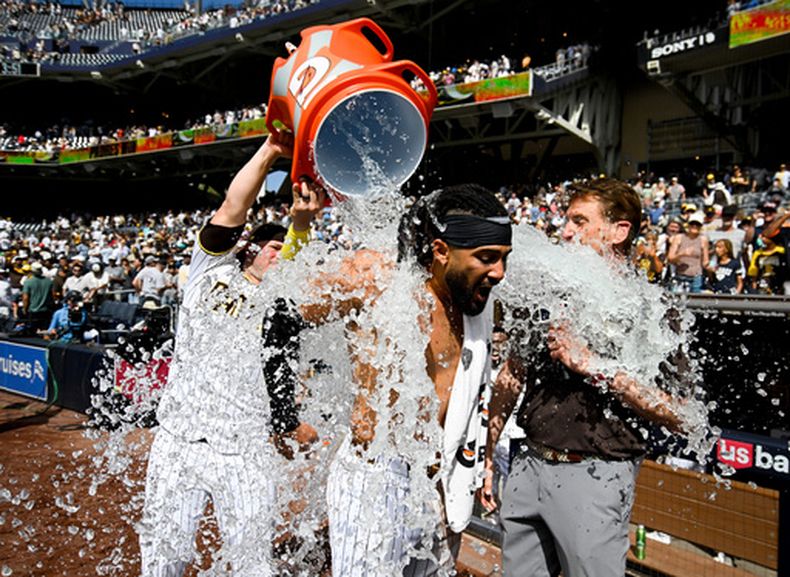 Fernando Tatis Jr., de los Padres de San Diego, recibe un baño después de dar el batazo decisivo del partido durante el juego de béisbol de Grandes Ligas ante los Rojos de Cincinnati, el miércoles10 de junio de 2026, en San Diego. (AP Foto/Denis Poroy)