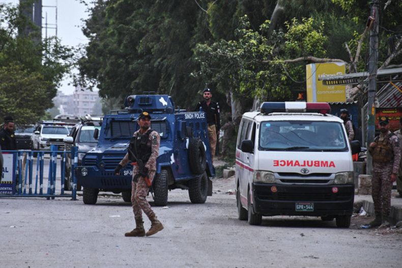 Soldados paramilitares y agentes de policía montan guardia en una carretera cortada cerca del lugar de n ataque contra la sede provincial de un cuerpo paramilitar de exploradores en Karachi, Pakistán, el domingo 28 de junio de 2026. (AP Foto/Ali Raza)