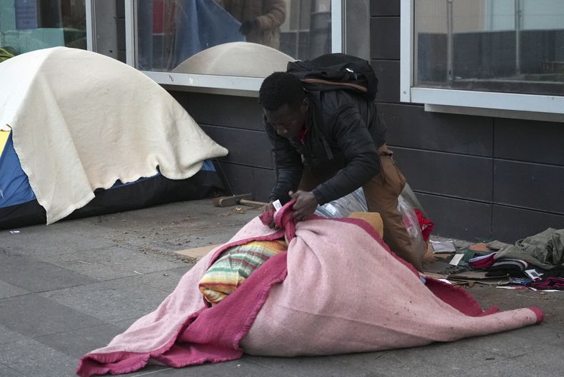 Un migrante empaca sus pertenencias en un campamento improvisado, el martes 23 de abril en París, Francia. La policía francesa desalojó el martes a varios migrantes de un campamento improvisado en París a unos pasos del río Sena, una nueva operación en lo que grupos de ayuda describen como una campaña de “limpieza social” antes de los Juegos Olímpicos. (AP Foto/Nicolas Garriga)