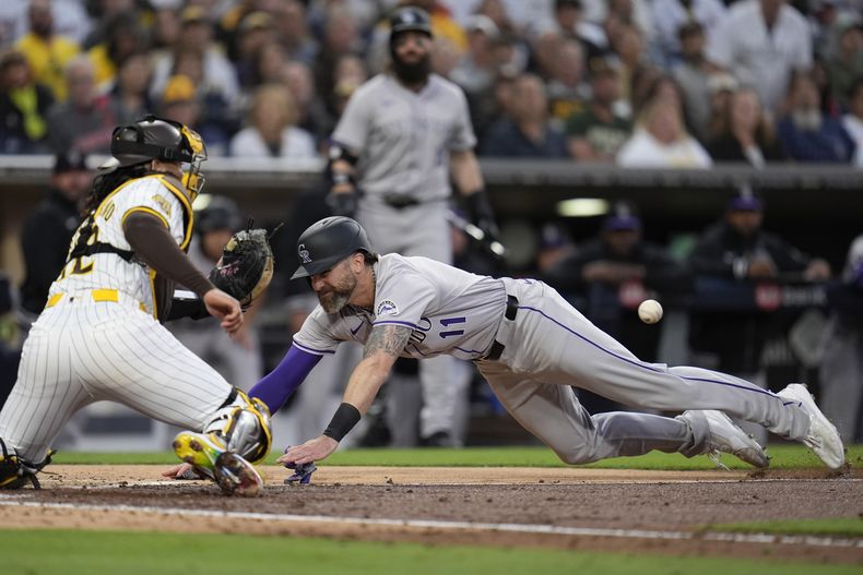 Jake Cave, derecha, de los Rockies de Colorado, anota desde primera con doble productor de Elehuris Montero mientras que el receptor de los Padres de San Diego, Luis Campusano, espera por la pelota durante la cuarta entrada del juego de béisbol del lunes 13 de mayo de 2024, en San Diego. (AP Foto/Gregory Bull)