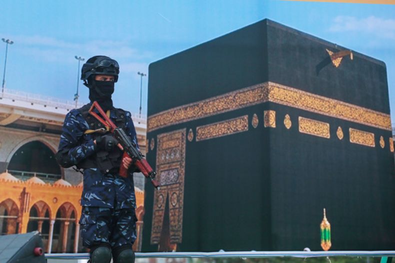 Un soldado hutí, delante de un cartel de grandes dimensiones con la imagen de la Kaaba, durante una manifestación para protestar contra la acusación de Arabia Saudí de que los rebeldes atacaron el sitio más sagrado del islam, en Saná, Yemen, el 18 de septiembre de 2026. (AP Foto/Osamah Abdulrahman)