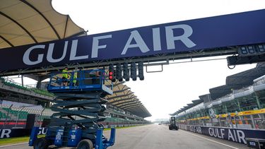 Unos trabajadores utilizan una plataforma de tijera para instalar una pancarta sobre la pista antes del Gran Premio de Bahrein en Malasia, en el Circuito Internacional de Sepang, el miércoles 30 de septiembre de 2026, en Sepang, Malasia. (Foto AP/Vincent Thian)