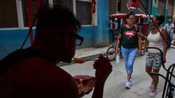 Un conductor de bicitaxi come desde su bicicleta durante un apagón en La Habana, Cuba, el lunes 6 de julio de 2026. (AP Foto/Ramón Espinosa)