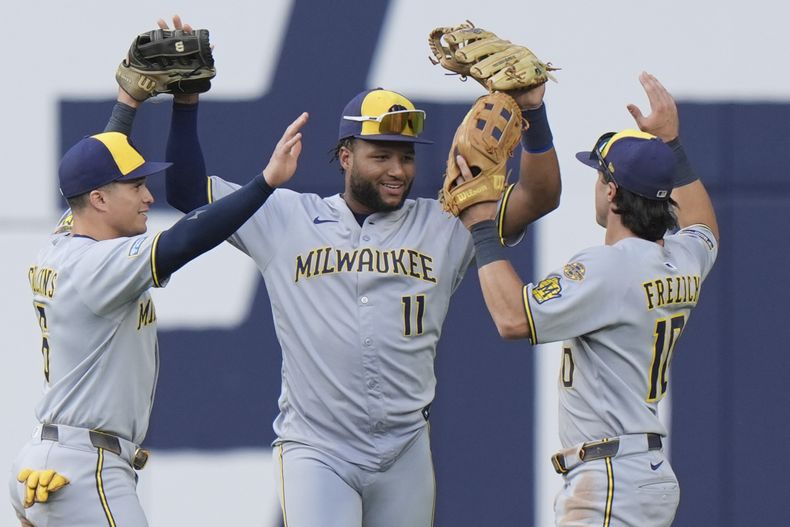 Isaac Collins, Jackson Chourio y Sal Frelick de los Cerveceros de Milwaukee celebran la victoria ante los Azulejos de Toronto el sábado 30 de agosto del 2025. (Frank Gunn/The Canadian Press via AP)