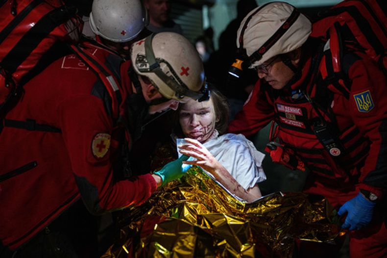 Voluntarios de Cruz Roja ayudan a una mujer herida en un refugio tras un ataque ruso a un vecindario residencial en Kiev, Ucrania, el domingo 24 de mayo de 2026. (AP Foto/Evgeniy Maloletka)