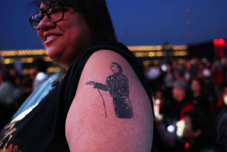 Una fan de Juan Gabriel muestra su tatuaje mientras se une a otros admiradores en una proyección gratuita del concierto que el fallecido cantante mexicano Juan Gabriel ofreció en 1990 en Bellas Artes, en el Zócalo, la plaza principal de la Ciudad de México, el sábado 8 de noviembre de 2025. (Foto AP/Claudia Rosel)