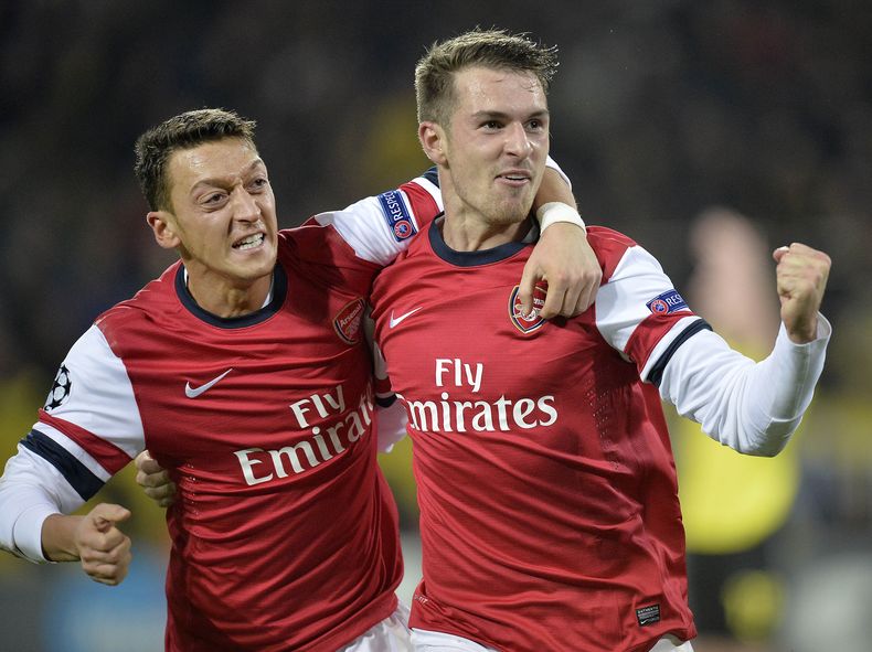 El jugador de Arsenal, Aaron Ramsey, derecha, festeja con su compa&ntilde;ero Mesut Oezil tras anotar un gol contra Borussia Dortmund en la Liga de Campeones el mi&eacute;rcoles, 6 de noviembre de 2013, en Dortmund, Alemania. (AP Photo/Martin Meissner)