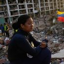 Estefany Landaez permanece sentada entre los escombros de un edificio esperando encontrar a sus dos hijos tras los terremotos en La Guaira, Venezuela, el domingo 12 de julio de 2026. (AP Foto/Ariana Cubillos)