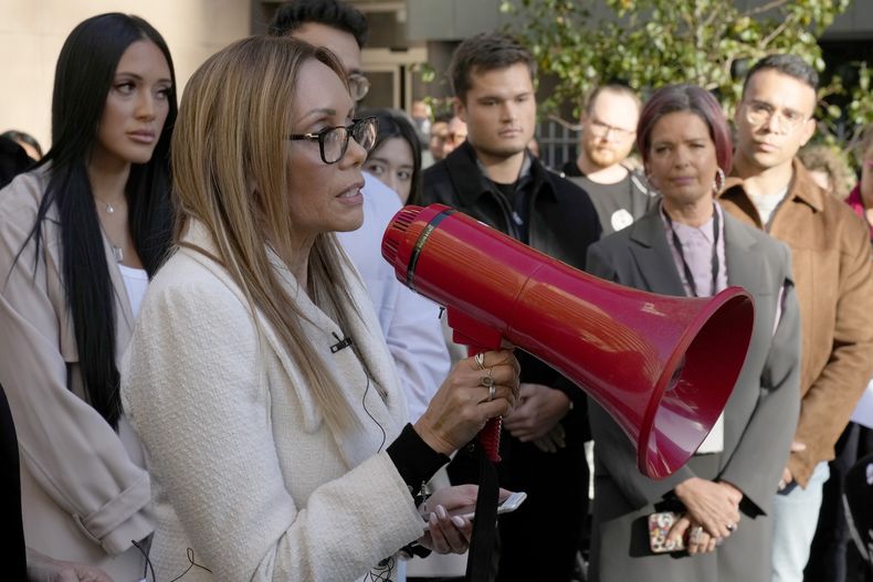 Karla Grant habla a trabajadores de la Australian Broadcasting Corp. (ABC) y otros simpatizantes, reunidos ante la oficina de la ABC en Sydney, el lunes 22 de mayo de 2023, para apoyar al exmarido de Karla, el periodista indígena Stan Grant. El conocido periodista indígena Stan Grant anunció que a partir del lunes dejaría de presentar programas de televisión, después de que algunos espectadores respondieran con actitudes racistas a sus comentarios sobre la expropiación histórica a los aborígenes durante un programa emitido antes de la coronación del rey Carlos III. (AP Foto/Rick Rycroft)
