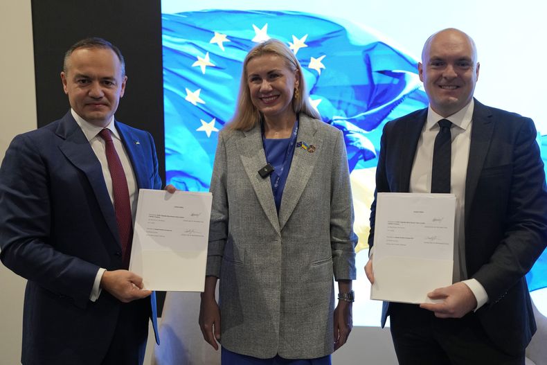 De izq a der: Maxim Timchenko, CEO de DTEK; Kadri Simson, comisionada europea para temas de energía y Morten Dyrholm, de la compañía Vestas, en el pabellón de Ucrania en la COP28, en Dubái, Emiratos Árabes Unidos, el 4 de diciembre de 2023. (Foto AP /Rafiq Maqbool)
