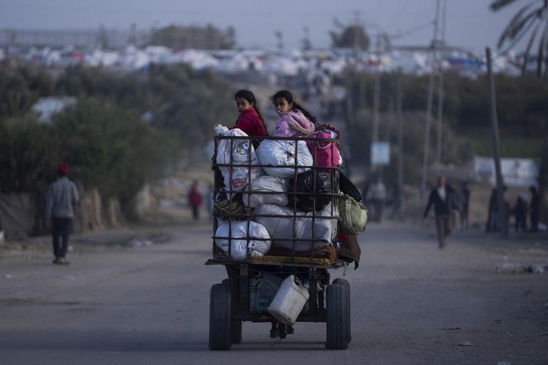 Palestinos que huyeron de la ofensiva terrestre israelí en Jan Yunis y de la campaña aérea en la Franja de Gaza, llegan a Rafah, en el extremo sur del enclave, el 22 de enero de 2024. (AP Foto/Fatima Shbair).