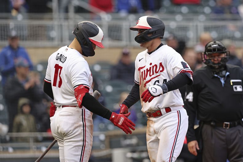 El puertorriqueño José Miranda (derecha) es felicitado por Joey Gallo, luego de conectar un jonrón ante los Reales de Kansas City, el viernes 28 de abril de 2023 (AP Foto/Stacy Bengs)