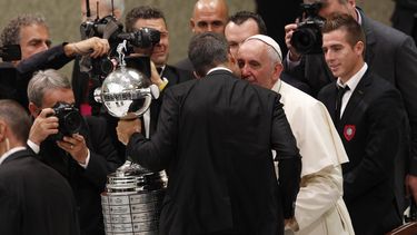 americateve | El papa Francisco, sonriente, tom&oacute; con sus dos manos la gigantesca Copa Am&eacute;rica que una delegaci&oacute;n del club argentino San Lorenzo le mostr&oacute; al t&eacute;rmino de la audiencia p&uacute;blica del mi&eacute;rcoles 20 de agosto de 2