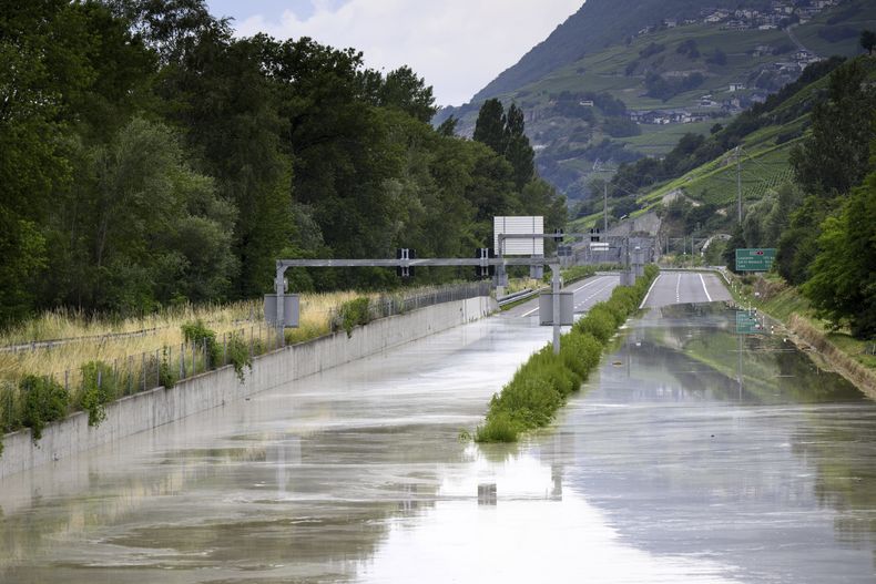 El río Ródano se desborda sobre la autopista A9 tras tormentas que provocaron grandes inundaciones, en Sierre, Suiza, el domingo 30 de junio de 2024. (Jean-Christophe Bott/Keystone via AP)