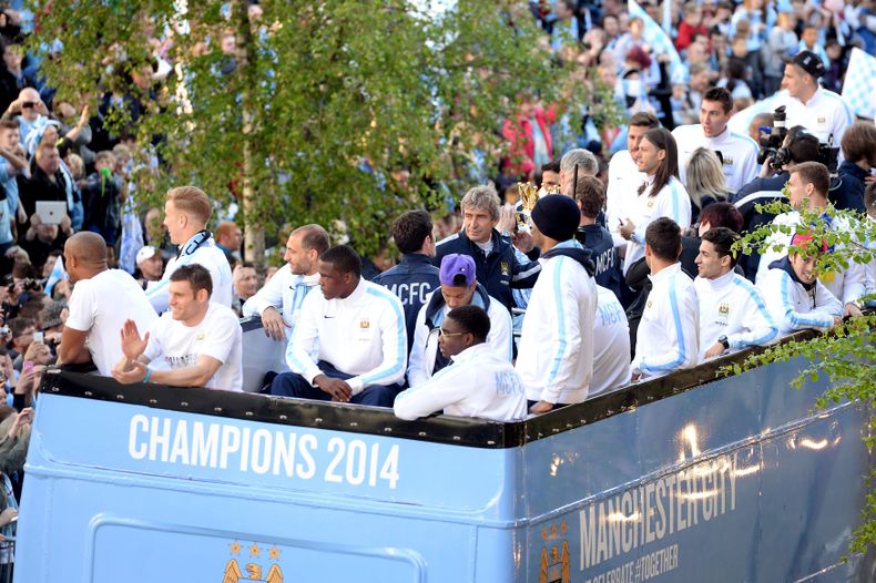 Los jugadores de Manchester City, con su t&eacute;cnico Manuel Pellegrini en el centro, recorren la ciudad en un autob&uacute;s de dos pisos descapotado para festejar la conquista de su segunda Liga Premier en tres a&ntilde;os el 12 de mayo del 2014. (AP