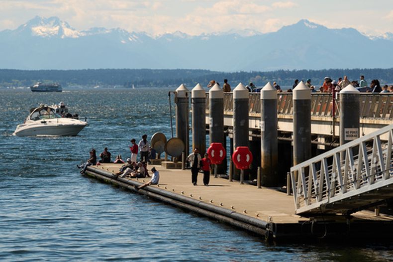 Un grupo de visitantes disfruta los muelles frente a la Bahía Elliott de Seattle, el sábad 25 de 2026 (AP Foto/Lindsey Wasson)
