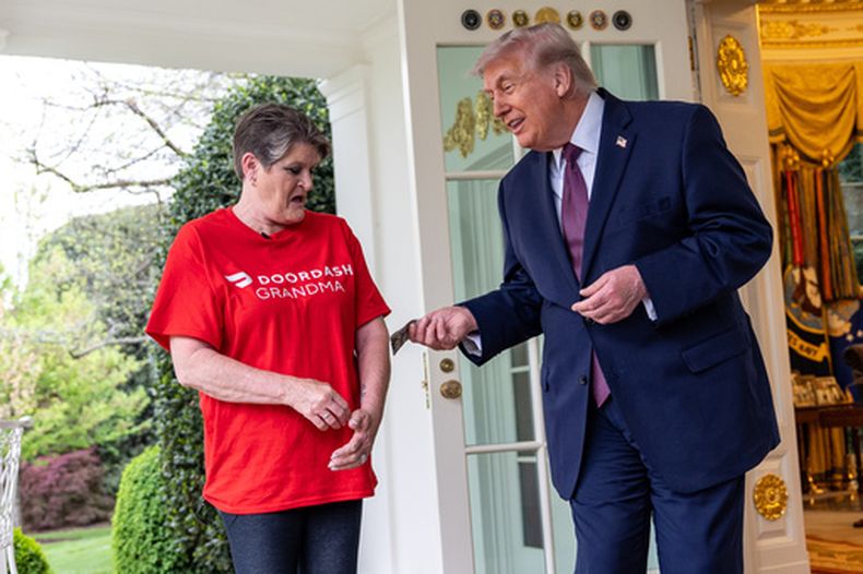 Sharon Simmons, repartidora de DoorDash, recibe una propina de 100 dólares después de llevarle un pedido de McDonalds al presidente Donald Trump en el Despacho Oval de la Casa Blanca, el lunes 13 de abril de 2026, en Washington. (AP Foto/Alex Brandon)