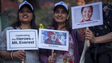 Tres mujeres sostienen carteles y fotos en homenaje a montañeros con récords, en los actos por el 70mo aniversario del primer ascenso a la cima del Everest en Katmandú, Nepal, el lunes 29 de mayo de 2023. (AP Foto/Niranjan Shrestha)