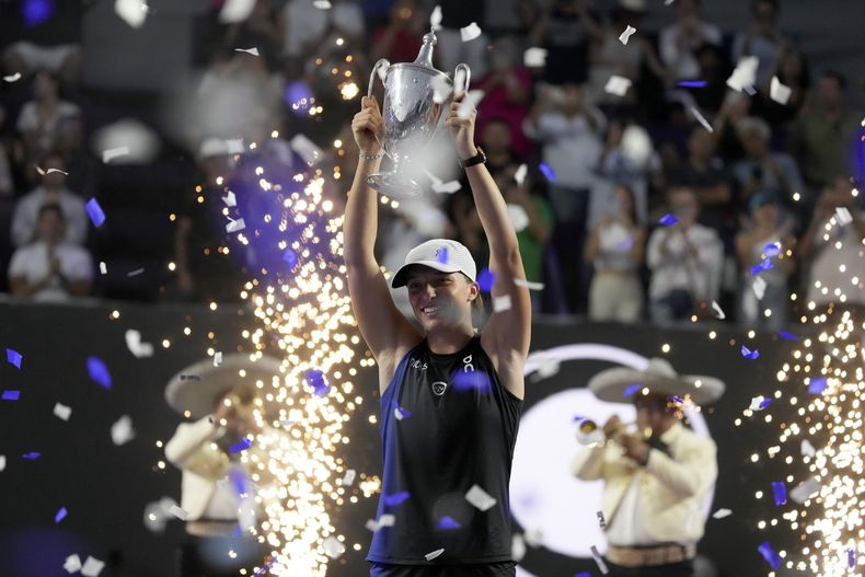 ARCHIVO - La polaca Iga Swiatek alza su trofeo de campeonas de las Finales de la WTA tras derrotar a Jessica Pegula en la final, el lunes 6 de noviembre de 2023, en Cancún, México. (AP Foto/Fernando Llano)