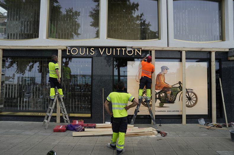 Trabajadores de construcción colocan tablas delante de un escaparate antes de protestas previstas contra la cumbre del G7 en Ginebra, Suiza, el lunes 8 de junio de 2026. (AP Foto/Baz Ratner)