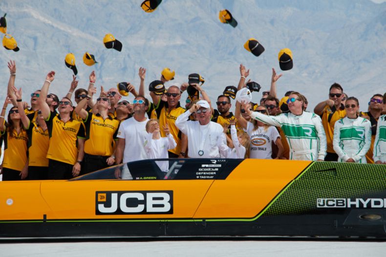 El conductor británico Andy Green, centro, y el equipo de ingeniería de JCB celebran un nuevo récord de velocidad en tierra para un vehículo impulsado por hidrógeno en el Salar de Bonneville, en Utah, el martes 11 de agosto de 2026. (AP Foto/Hannah Schoenbaum)