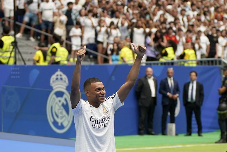 El futbolista francés Kylian Mbappé saluda a los aficionados durante su presentación como jugador del Real Madrid en el estadio Santiago Bernabéu, en Madrid, el 16 de julio de 2024. (AP Foto/Andrea Comas)