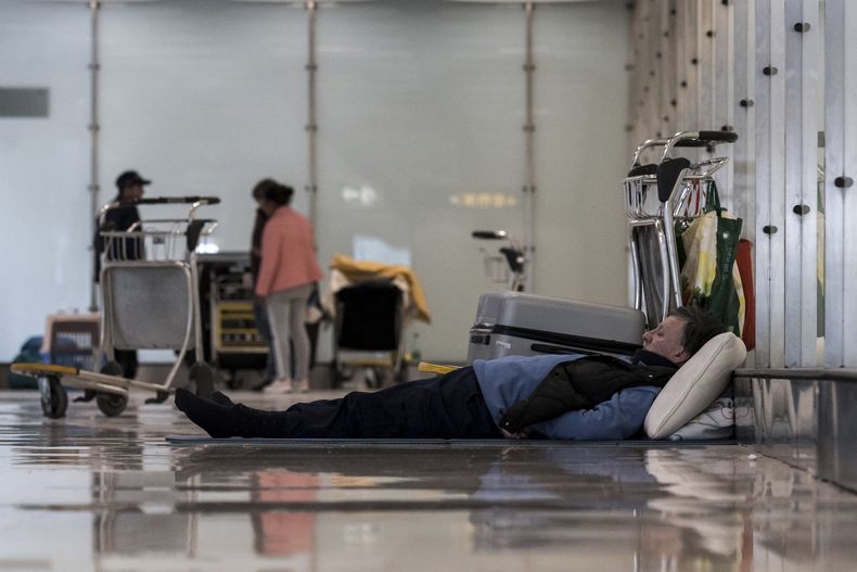 Una persona duerme en el piso de la terminal 4 del aeropuerto Adolfo Suárez-Madrid Barajas en Madrid, España, el 12 de mayo de 2025. (Diego Radames/Europa Press via AP)